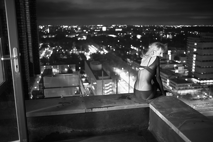 Woman sitting on the edge of a building.